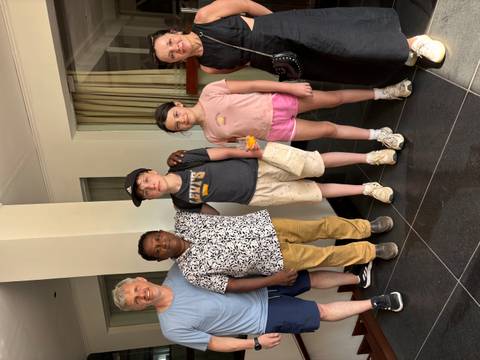       Family poses with local driver inside a hotel lobby
  