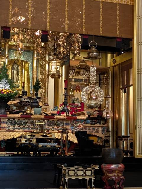       Lavishly decorated Buddhist altar with gold ornaments, candles and intricate carvings
  