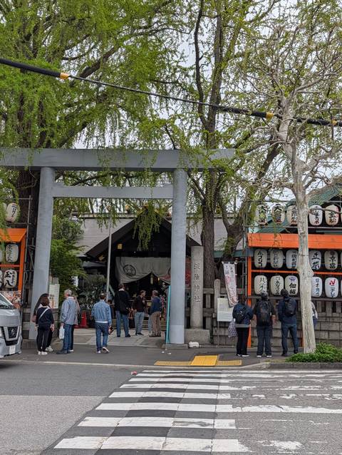       Entrance torii gate leading into a bustling shrine complex with hanging lanterns
  