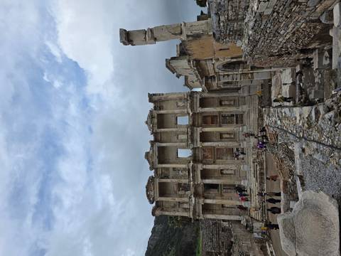       Ancient facade of the Library of Celsus in Ephesus standing against a cloudy sky.
  