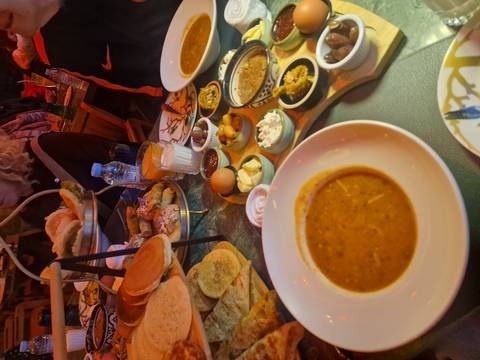       Spread of traditional Moroccan dishes and breads on a busy restaurant table
  