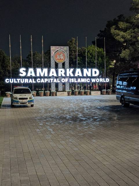       Night view of an illuminated city sign reading 'SAMARKAND Cultural Capital of Islamic World'.
  