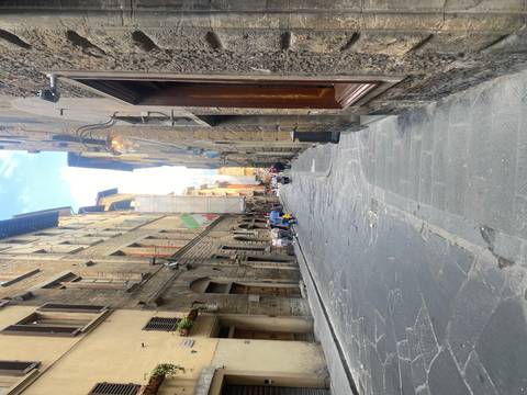       Narrow cobblestone street lined with historic stone buildings in an Italian city
  