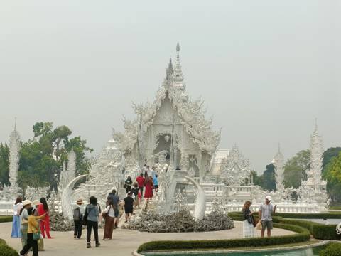       Crowds explore the intricate alabaster buildings of Wat Rong Khun, the famous White Temple.
  