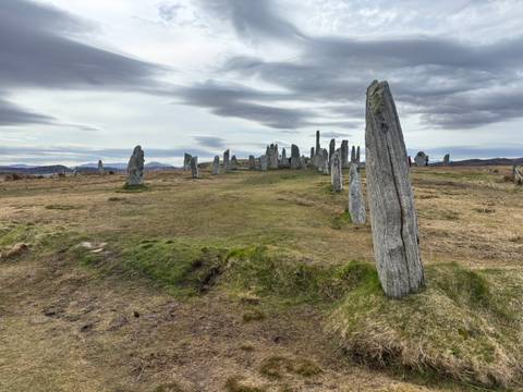       Ancient standing stones of the Callanish Stone Circle set against dramatic skies and rolling moorland
  