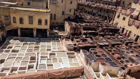       Panoramic view over the tannery pits of Fes with hides drying on surrounding rooftops
  