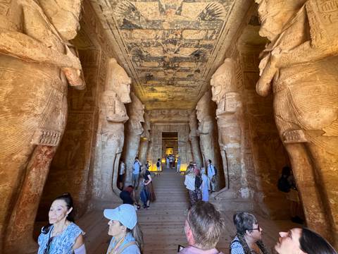       Colossal statues line the interior corridor of Abu Simbel Temple crowded with visitors
  