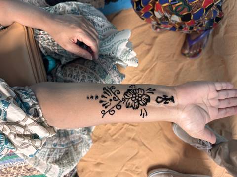       Forearm decorated with fresh black henna design featuring an ankh symbol
  