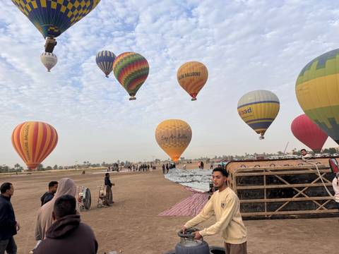       Colorful hot-air balloons lift off at dawn above the desert plain of Luxor
  