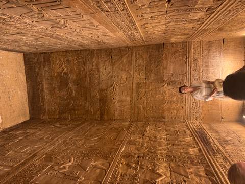       Guide explains hieroglyph-covered chamber walls illuminated by warm light
  