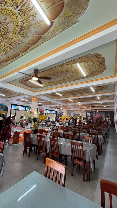       Spacious Vietnamese buffet restaurant with ornate ceiling panels and diners serving themselves
  