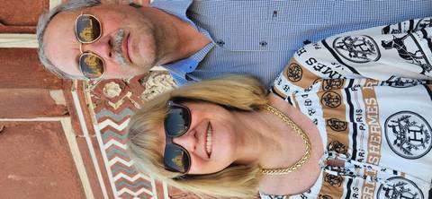       Creative portrait of couple with the Taj Mahal reflected in their sunglasses lenses.
  