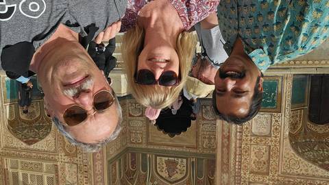       Selfie with local guide outside a richly painted Mughal gateway at Amber Fort.
  