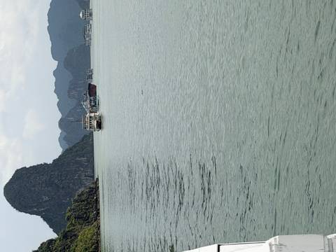       Boats cruise among limestone karsts in the calm waters of Ha Long Bay.
  