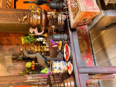       Still life of ritual objects, incense and a brass censer on a dark wooden altar.
  