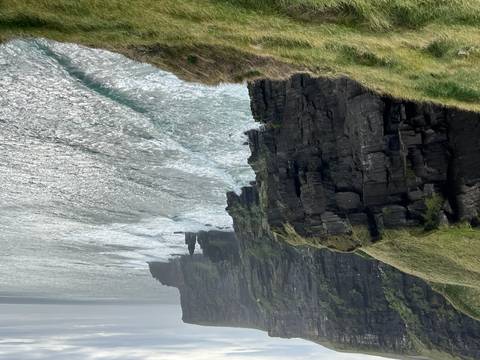       Dramatic cliffs plunge into the Atlantic with waves crashing below.
  