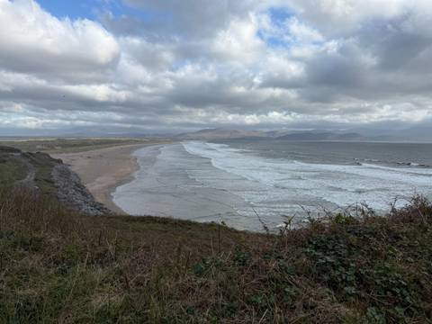       Wide sandy Atlantic beach and rolling surf beneath cloudy skies.
  