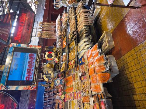      A vibrant seafood market stall displays fish, shellfish and dried products.
  
