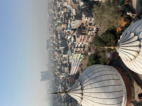       Aerial cityscape of Old Delhi with mosque domes in foreground under hazy sky.
  