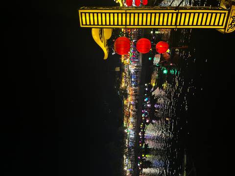       Nighttime lantern festival reflections on the river in Hoi An with glowing red lanterns in the foreground.
  