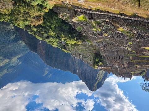       Majestic ruins of Machu Picchu sprawling over lush terraces with the dramatic Huayna Picchu peak looming beyond.
  