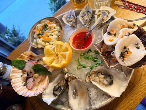       Assorted fresh oysters, ceviche and garnishes arranged on crushed ice with a bright lemon centerpiece.
  