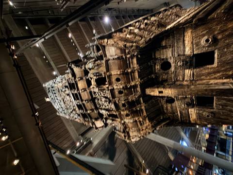       Dramatic upward view of the preserved 17th-century Vasa warship inside the Vasa Museum.
  