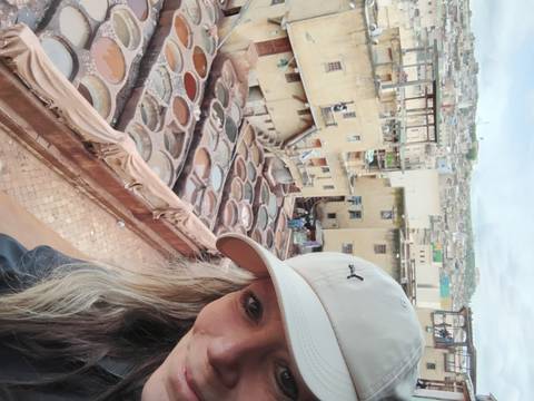       Close-up selfie capturing the multi-level dye pits of Fes tanneries in the background.
  