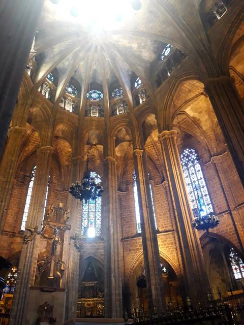       Sunlit stained-glass windows and soaring columns inside a Gothic cathedral.
  