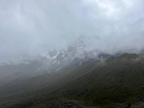       Misty, cloud-shrouded Andean peak barely visible through thick fog.
  