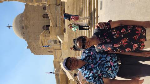       Couple posing in front of a domed church in Cairo on a bright sunny day.
  