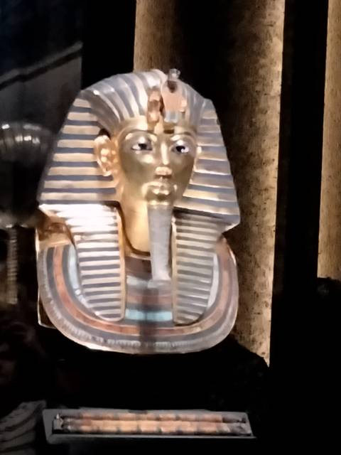       Close-up of a slightly blurred golden funerary mask of an ancient Egyptian pharaoh.
  