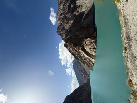       Turquoise lake surrounded by rugged brown mountains under a clear deep-blue sky
  