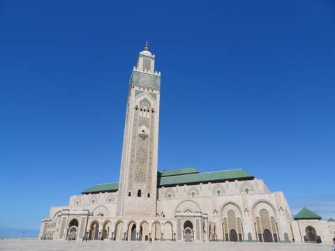       Hassan II Mosque with its tall minaret rising against a deep blue sky in Casablanca
  