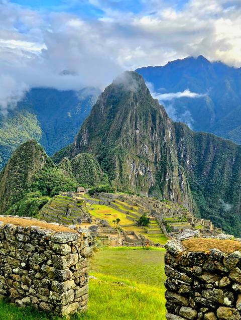       Classic panoramic view of Machu Picchu ruins nestled among steep green Andean peaks
  
