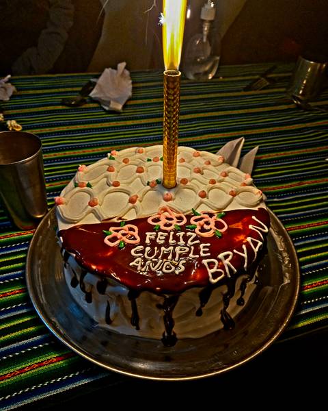       Decorated birthday cake with Spanish icing message on colourful textile
  