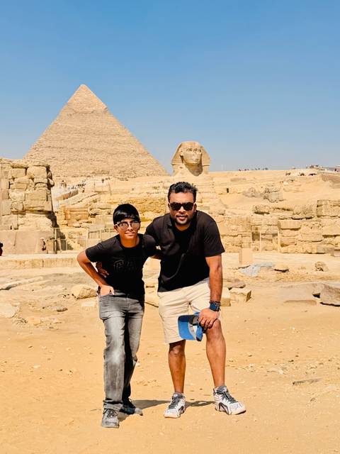       Father and son in front of Sphinx and pyramid complex
  