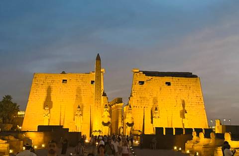       Main pylon of Luxor Temple dramatically lit at twilight with obelisk shadow
  