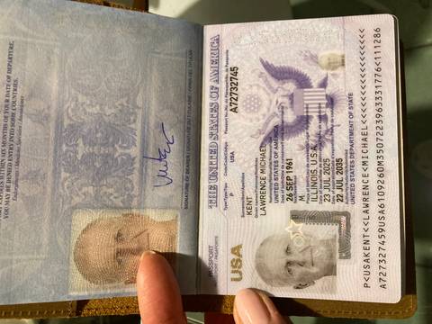       Close-up of an opened passport displaying holder information and visa page held by a hand.
  