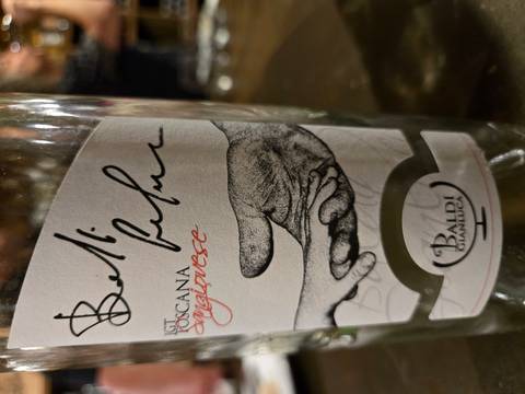       Close-up of a Tuscan Sangiovese wine bottle label featuring an artistic hand illustration
  