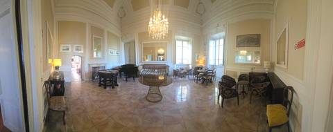       Opulent villa salon with chandelier, grand piano, and antique furnishings
  