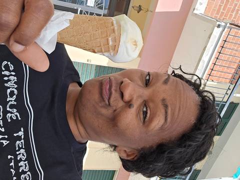       Woman taking a selfie with a gelato cone, smiling playfully
  