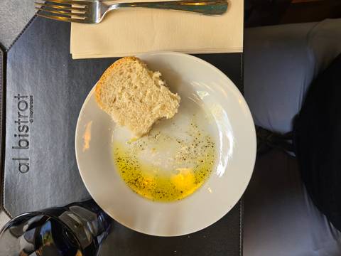      Plate of olive oil and bread at a restaurant table
  