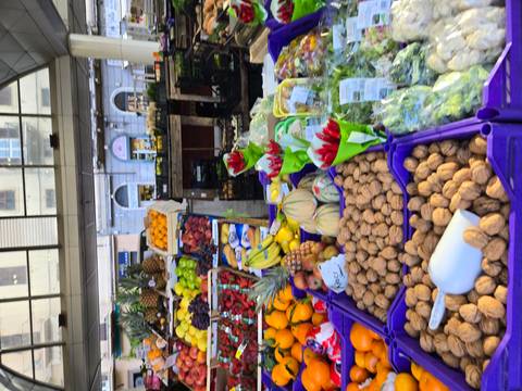       Colorful produce market with fruits, nuts and vegetables displayed in plastic crates
  