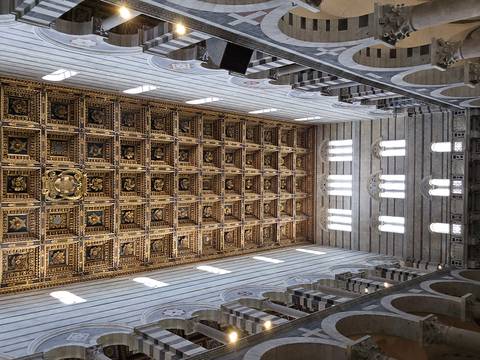       Intricately gilded wooden ceiling and high nave windows of Pisa Cathedral interior
  