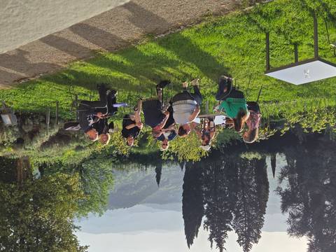       Small group enjoying drinks at outdoor tables overlooking green Tuscan hills
  