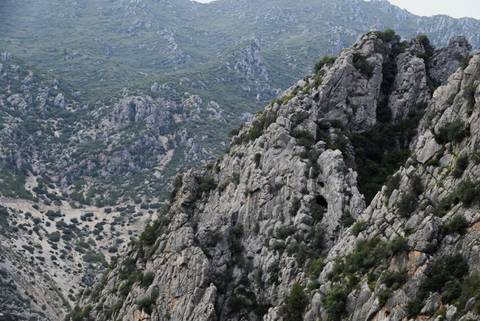       Steep gray limestone ridges rising above a rugged valley in northern Morocco.
  