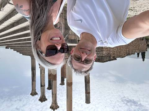       Selfie of a couple at the Roman ruins of Volubilis with tall columns in the background.
  