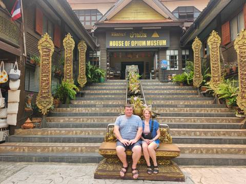       Couple seated on ornate bench outside the House of Opium Museum
  