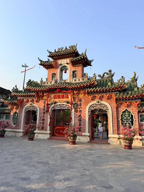       Ornate pink Fujian Assembly Hall in Hoi An decorated with dragons and lanterns
  